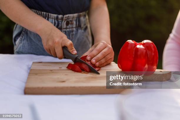 menina cortando um pimentão vermelho - red bell pepper - fotografias e filmes do acervo