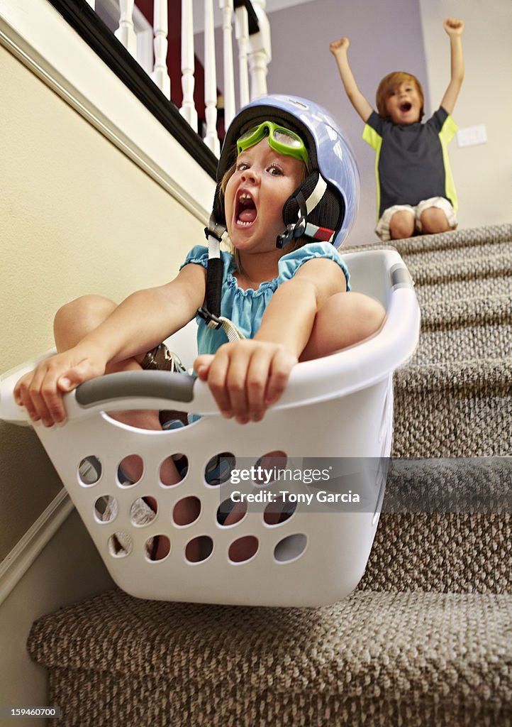Girl going down stairs in laundry basket