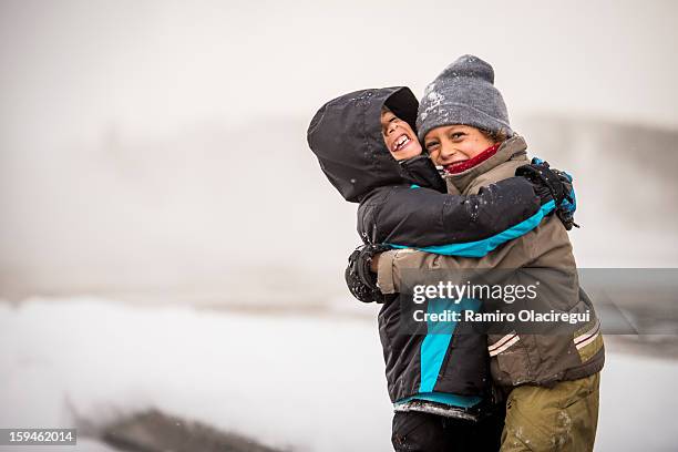 two boys. friends. big hug. snow. winter - big sky ski resort stock pictures, royalty-free photos & images