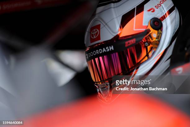 Bubba Wallace, driver of the DoorDash Toyota, sits in his car during qualifying for the NASCAR Cup Series FireKeepers Casino 400 at Michigan...