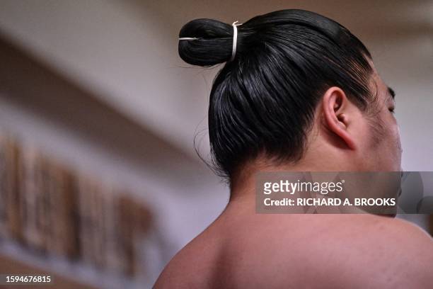 This photo taken on June 6, 2023 shows the "top-knot" of a sumo wrestler during a training session at the Arashio-beya sumo stable in Tokyo. The...