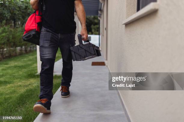 nahaufnahme der werkzeugtasche, die der elektriker trägt, als er das haus verlässt, in dem er die klimaanlage installiert hat - werkzeugtasche stock-fotos und bilder