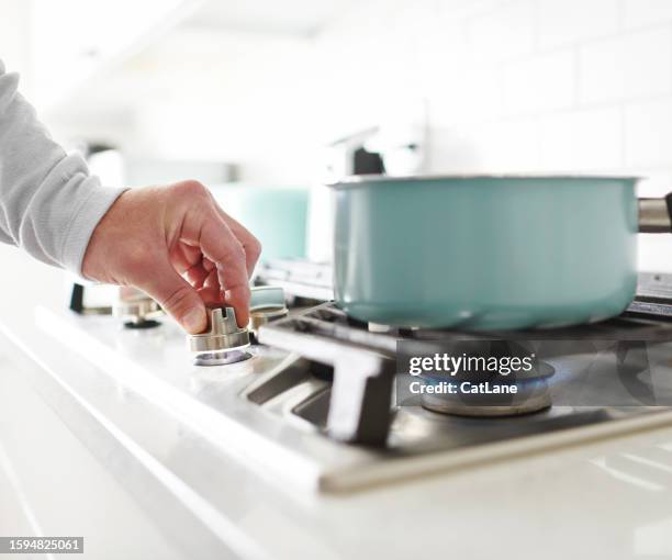 unidentifiable male cooking food on a gas stove - stove stock pictures, royalty-free photos & images