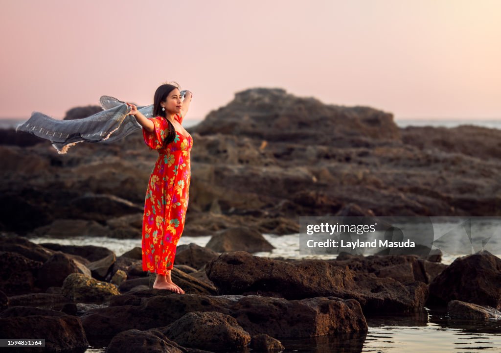 Beautiful Woman Standing On Rock Holding Scarf
