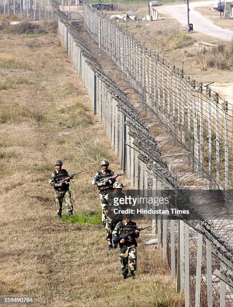 Indian Border Security Force soldier stands guard during a patrol near international border fencing at Suchet Garh in Ranbir Singh Pura on January...