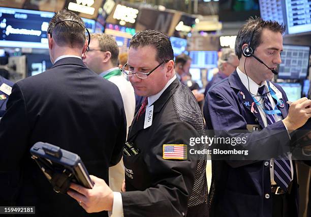 Traders work at the New York Stock Exchange in New York, U.S., on Monday, Jan. 14, 2013. U.S. Stocks fell, after the Standard & Poor's 500 Index...