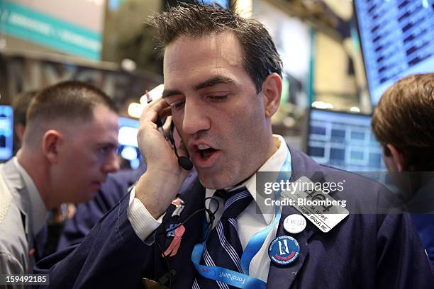 Gregory Rowe, a trader with Livermore Trading Group Inc., works at the New York Stock Exchange in New York, U.S., on Monday, Jan. 14, 2013. U.S....