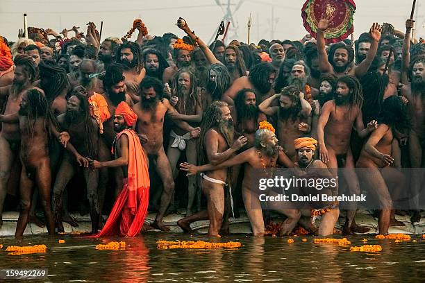 Naga sadhus line up along the banks of Sangam, the confluence of the holy Ganges and Yamuna rivers during the auspicious bathing day of Makar...