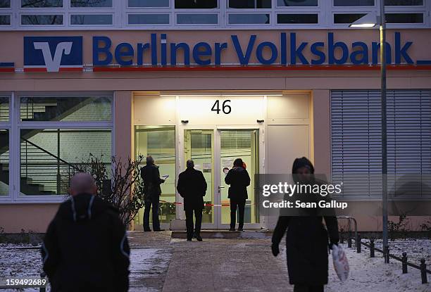 People approach a locked Steglitz district branch of Berliner Volksbank following a robbery of the bank that likely occured in the early morning...