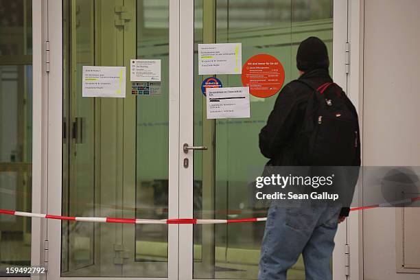 Man reads notices at the entrance to a locked Steglitz district branch of Berliner Volksbank following a robbery of the bank that likely occured in...