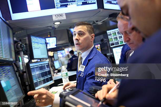 Traders work at the New York Stock Exchange in New York, U.S., on Monday, Jan. 14, 2013. U.S. Stocks fell, after the Standard & Poor's 500 Index...