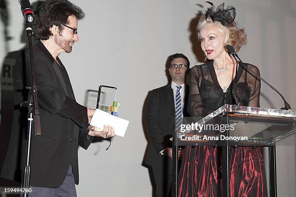 Actress Julie Newmar accepting an award which is being presented by an actor George Chakiris at the GLEH's Golden Globe viewing gala at Jim Henson...