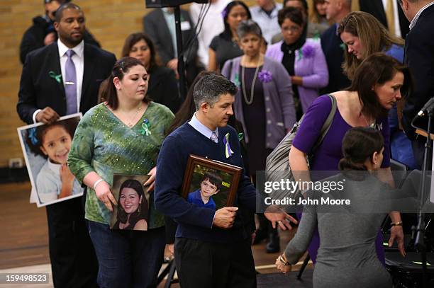 Ian Hockley , holds a photo of his son Dylan Hockley , while arriving with fellow parents of Sandy Hook Elementary victims for a press conference...