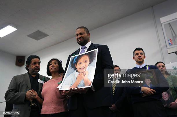 Jimmy Green holds a photo of his daughter Anna Grace Marquez Green during a press conference with fellow parents on the one month anniversary of the...