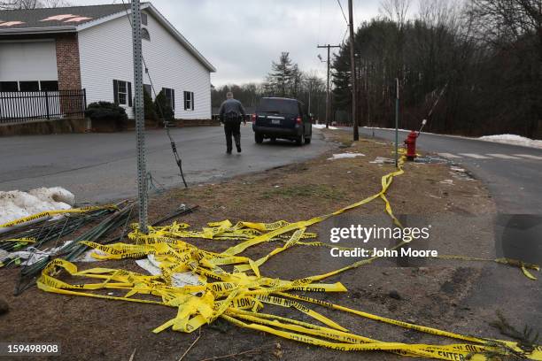 Police tape lies bunched near the road to Sandy Hook Elementary School on January 14, 2013 in Newtown, Connecticut. The town marked a month...