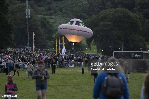 People gather and watch the event as balloons fly over Bristol during the Bristol International Balloon Fiesta on August 12, 2023 in Bristol, United...