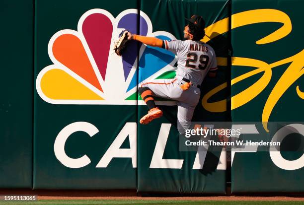 Luis Matos of the San Francisco Giants takes a hit away from Seth Brown of the Oakland Athletics by making a leaping catch while colliding with the...