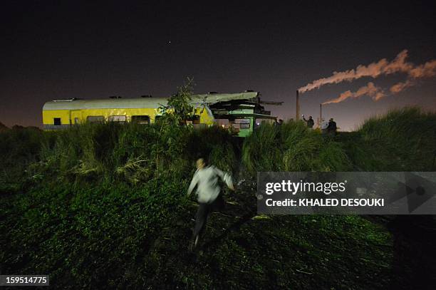 People inspect at the wreckage of a train in the Giza in Badrashin, about 40 km south of Cairo, on January 15 at least 19 people where killed and...