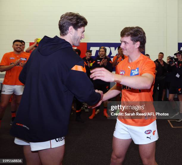 Callan Ward of GWS presents Toby McMullin with. His jumper during the 2023 AFL Round 22 match between the Port Adelaide Power and the GWS GIANTS at...