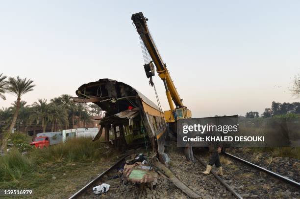 Egyptian workers remove the wreckage of a train in the Giza in Badrashin, about 40 km south of Cairo, on January 15 at least 19 people where killed...