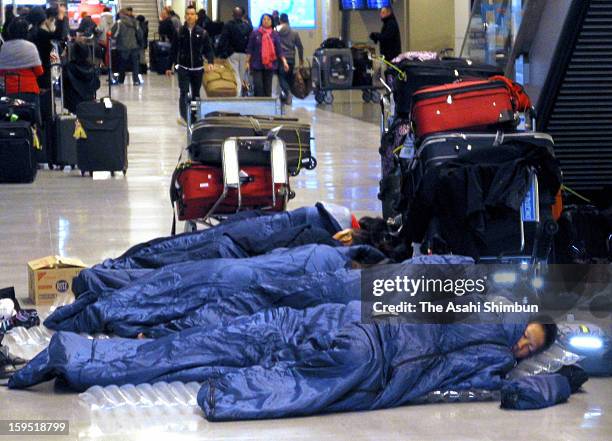 Passengers sleep in the sleeping bags provided by the airline companies due to the flights were cancelled due to the heavy snow and strong wind at...