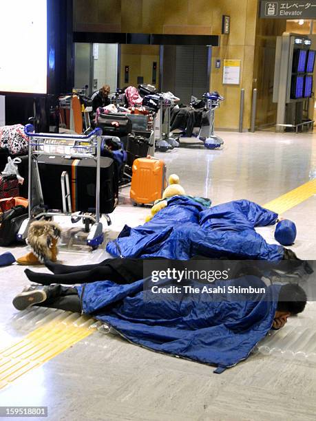 Passengers sleep in the sleeping bags provided by the airline companies due to the flights were cancelled due to the heavy snow and strong wind at...