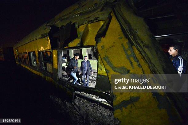 Egyptians inspect the wreckage of a train in the Giza neighbourhood of Badrasheen, about 40 kilometres south of Cairo, on January 15 after a train...