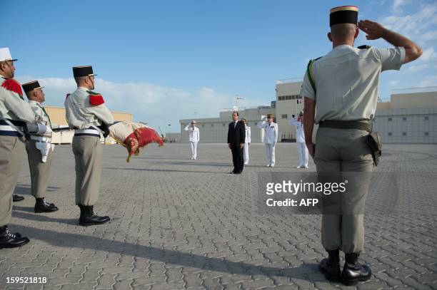France's President Francois Hollande reviews the troops at the French naval base "Camp de la Paix" in the Emirati capital Abu Dhabi on January 15,...
