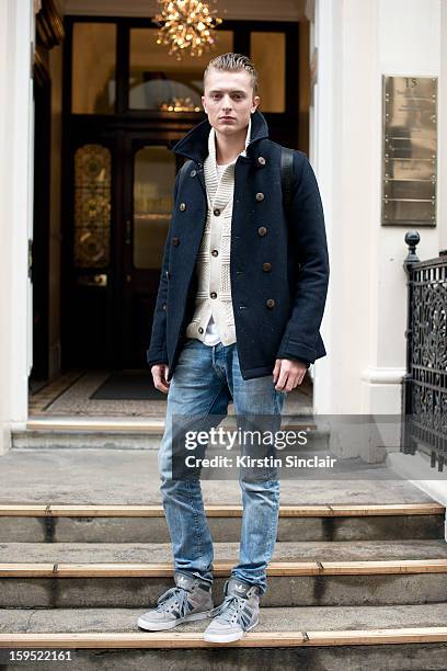 Max Rendell model wearing a Top Man Cardigan, coat and jeans, Louis Vuitton bag and adidas trainers on day 3 of London Mens Fashion Week...