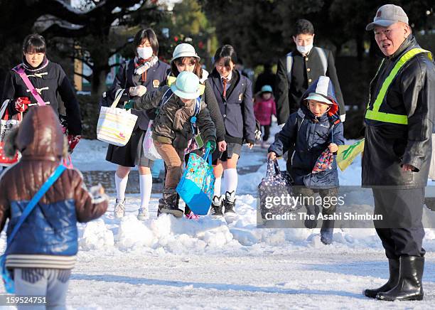 Students walk on a flozen road, a day after the snowfall on January 15, 2013 in Tokyo, Japan. A strong low pressure system caused heavy snow and...