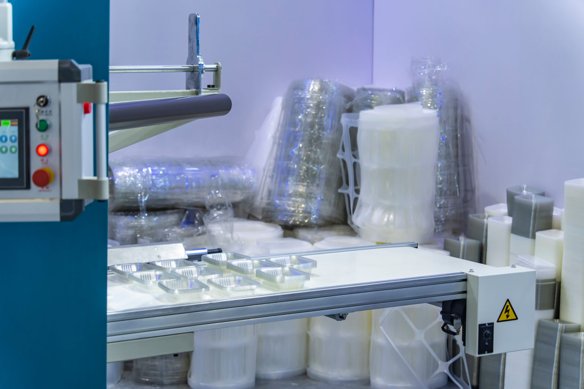 Stack of polypropylene food containers on conveyor belt of automatic plastic injection molding machine,automated technology concept Stack of polypropylene food containers on conveyor belt of automatic plastic injection molding machine,automated technology concept