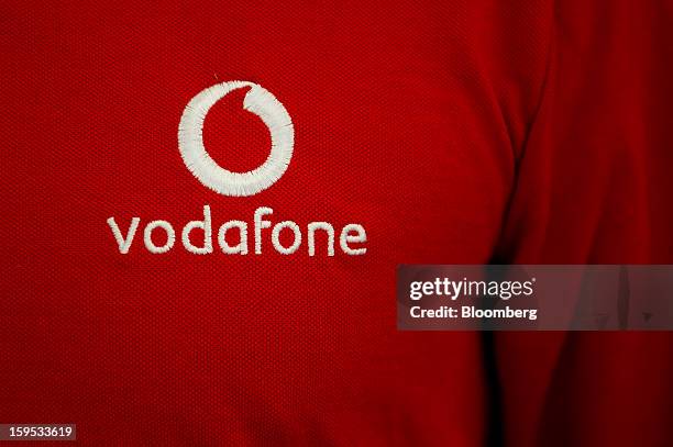 Vodafone Group Plc logo is seen on an employee's work shirt inside a company store in Barcelona, Spain, on Tuesday, Jan. 15, 2013. Vodafone Group...