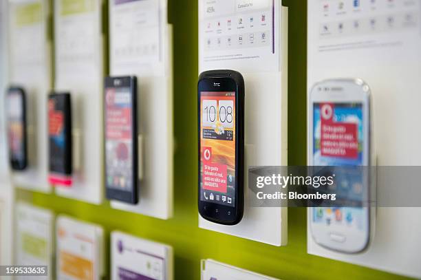 An HTC Corp. Mobile handset sits on a display of smartphones inside a Vodafone Group Plc store in Barcelona, Spain, on Tuesday, Jan. 15, 2013....