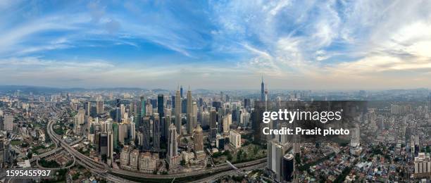 aerial view of kuala lumpur showing the petronas twin towers and other skyscrapers during sunset time in kuala lumpur malaysia - kuala lumpur twin tower stock pictures, royalty-free photos & images