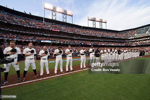 Members of the San Francisco Giants are seen on the third base path during the singing of the National Anthem before Game One of the 2012 World...