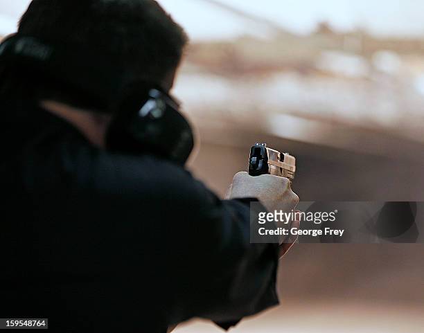 Brett Nielsen fires an Glock handgun at the "Get Some Guns & Ammo" shooting range on January 15, 2013 in Salt Lake City, Utah. Lawmakers are calling...