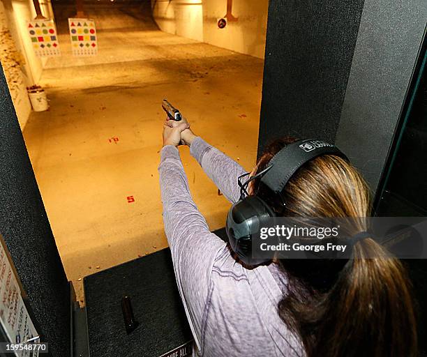 Women fires a handgun at the "Get Some Guns & Ammo" shooting range on January 15, 2013 in Salt Lake City, Utah. Lawmakers are calling for tougher gun...