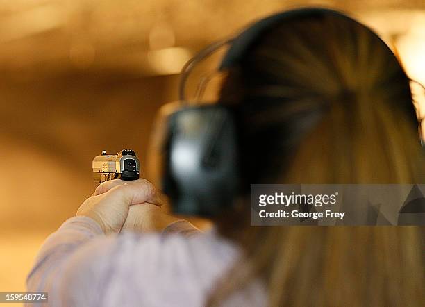 Women fires a handgun at the "Get Some Guns & Ammo" shooting range on January 15, 2013 in Salt Lake City, Utah. Lawmakers are calling for tougher gun...