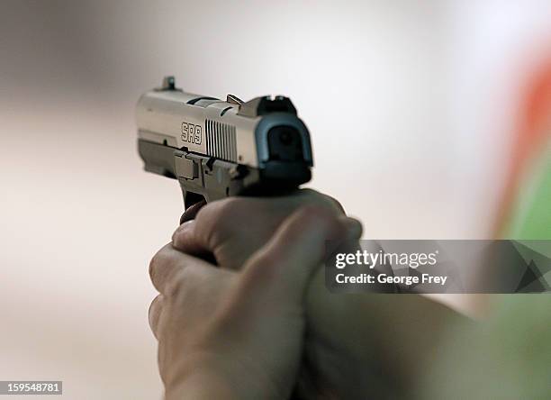 Women fires a handgun at the "Get Some Guns & Ammo" shooting range on January 15, 2013 in Salt Lake City, Utah. Lawmakers are calling for tougher gun...