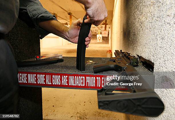 Man loads a high capacity ammo clip for an 22 Cal. Look-alike AR-15 rifle at the "Get Some Guns & Ammo" shooting range on January 15, 2013 in Salt...