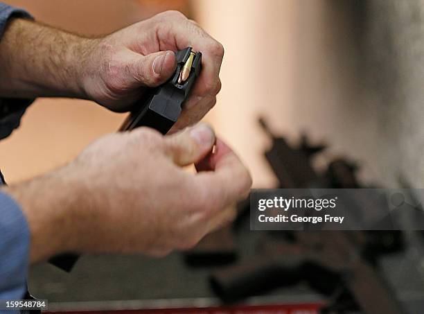 Man loads a high capacity ammo clip for an 22 Cal. Look-alike AR-15 rifle at the "Get Some Guns & Ammo" shooting range on January 15, 2013 in Salt...