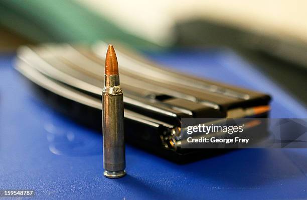 Ammunition and a high capacity 30 round clip sits on the table at the "Get Some Guns & Ammo" shooting range on January 15, 2013 in Salt Lake City,...