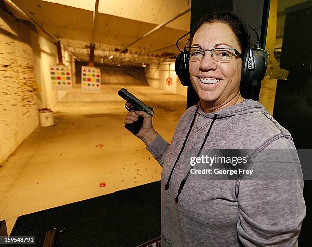 Women smiles after she fired a handgun at the "Get Some Guns & Ammo" shooting range on January 15, 2013 in Salt Lake City, Utah. Lawmakers are...