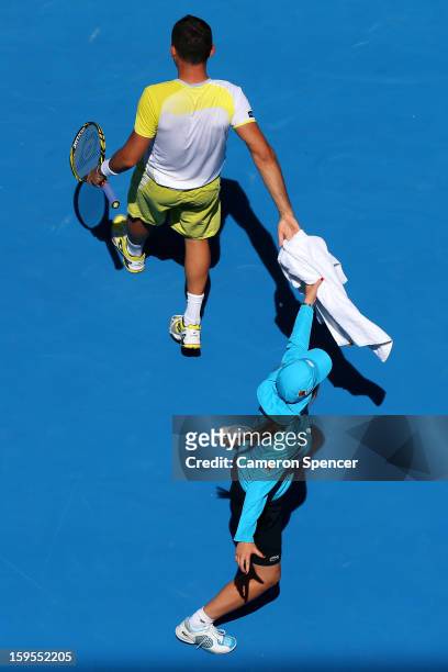 Nicolas Almagro of Spain hands a towel to a ball boy in his second round match against Daniel Gimeno-Traver of Spain during day three of the 2013...