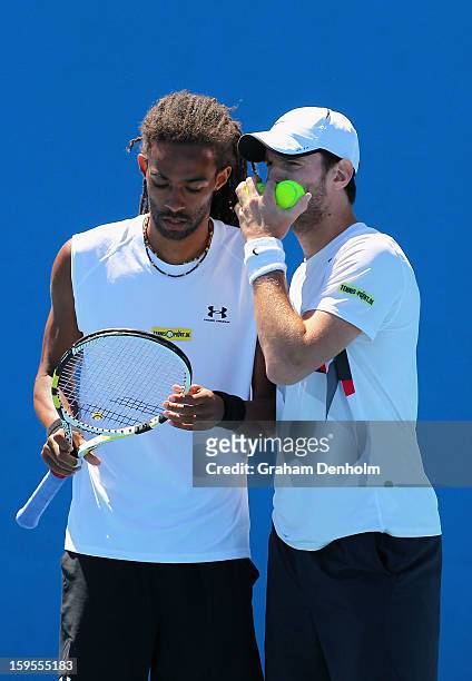 Dustin Brown and Christopher Kas of Germany talk tactics in their first round doubles match against Marcel Granollers and Marc Lopez of Spain during...