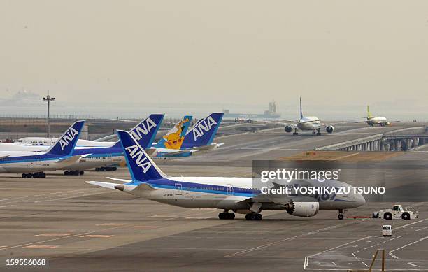 All Nippon Airways' Boeing 787 dreamliner is pulled by a towing tractor at Tokyo's Haneda airport on January 16, 2013 after a ANA Dreamliner...