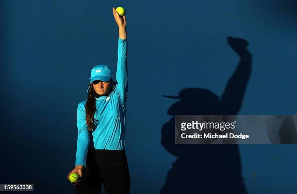 Ballgirl holds a ball up on an outside court late in the day during day three of the 2013 Australian Open at Melbourne Park on January 16, 2013 in...