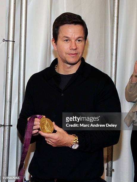Mark Wahlberg holds Kayla Harrison's Judo Olympic Gold Medal before the screening of "Broken City" hosted by Mark Wahlberg at Patriot Cinemas on...