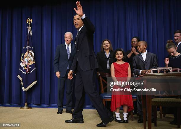 Joined by children who wrote letters to the White House about gun violence, U.S. President Barack Obama and Vice President Joe Biden wave goodbye...