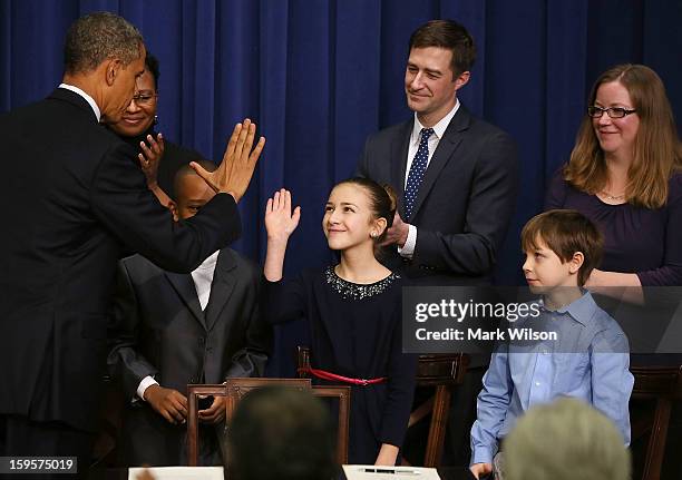 President Barack Obama gives high-fives to children who wrote letters to the White House about gun violence, Taejah Goode, Julia Stokes and Grant...